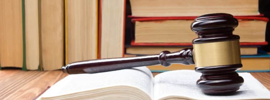 Law concept - Law book with a wooden judges gavel on table in a courtroom or law enforcement office